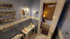 A bathroom with a glass sink, a toilet, a mirror, and a towel rack. - Pousada Vistacalma (Imbituba)