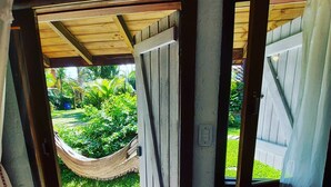 A doorway leading to a garden with a hammock. - Pousada Vistacalma (Imbituba)