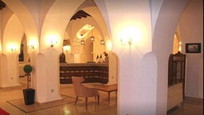 Eine Lobby mit gewölbten Decken, einem Empfangsbereich und einer Sitzecke.