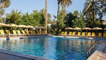 Relax by the pool surrounded by lush greenery and tropical plants.