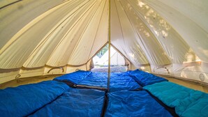 A dome-shaped tent with a central entrance and four sleeping areas with blue bedding. - Zarautz Beachside Surf Camp (Zarautz)