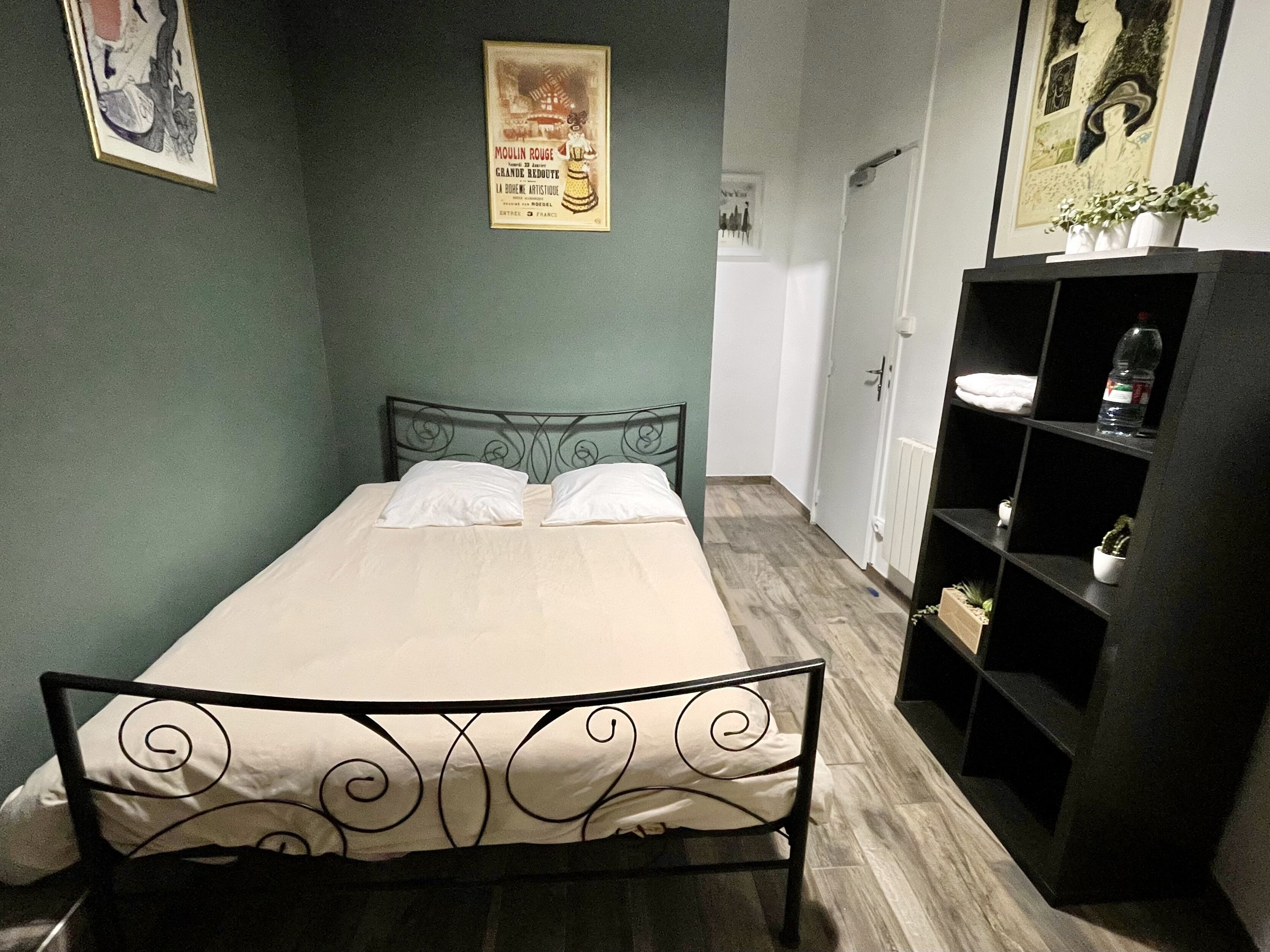 Ein Schlafzimmer mit einem Bett, einem Kleiderschrank und einem Poster an der Wand.