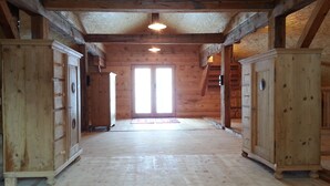 A spacious hallway with wooden floors and walls, leading to a bright doorway. - Ferienwohnungen am Berg - Almhütte Alfen (Innervillgraten)