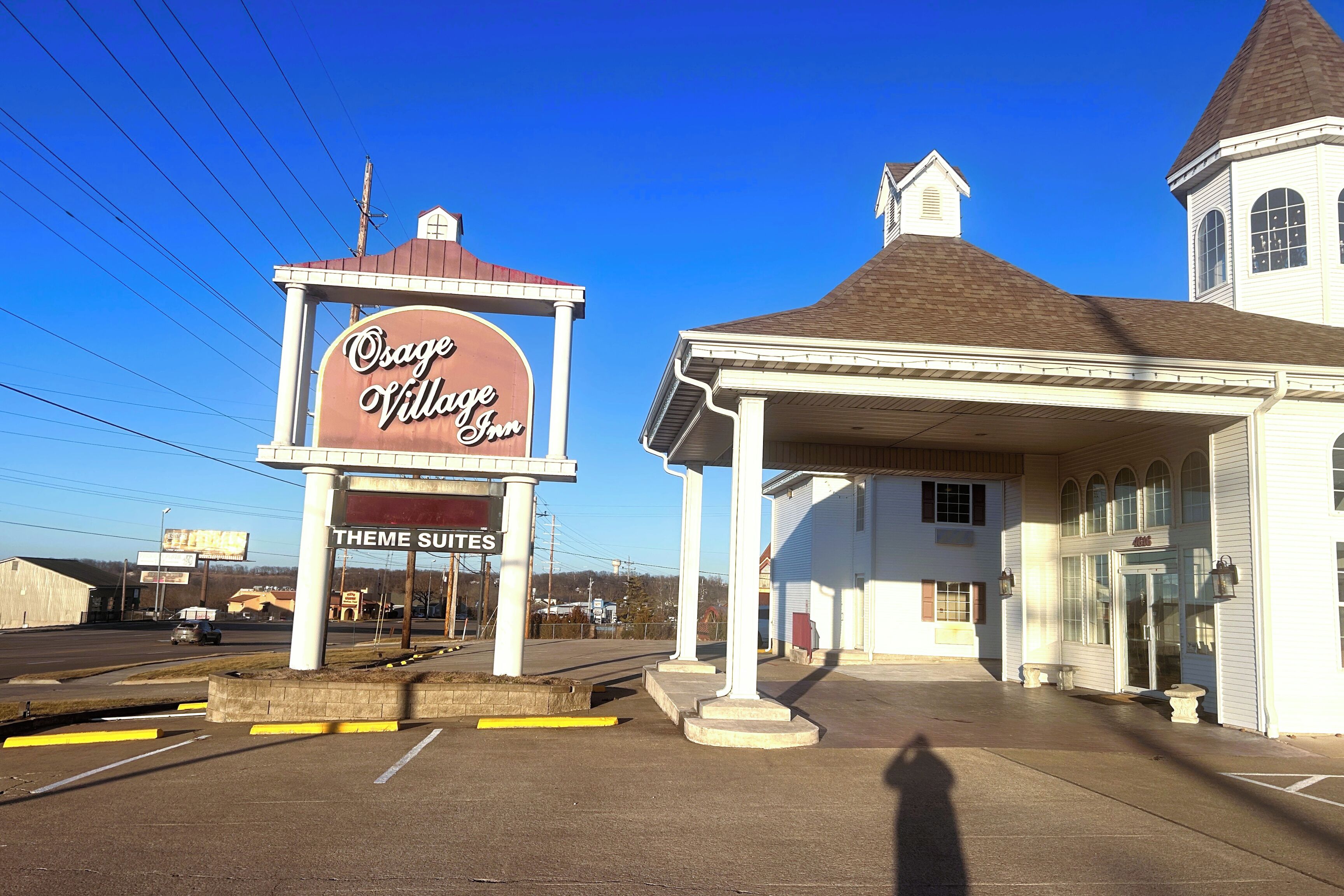 A building with a sign for 'Osage Village Inn' and 'Theme Suites.'