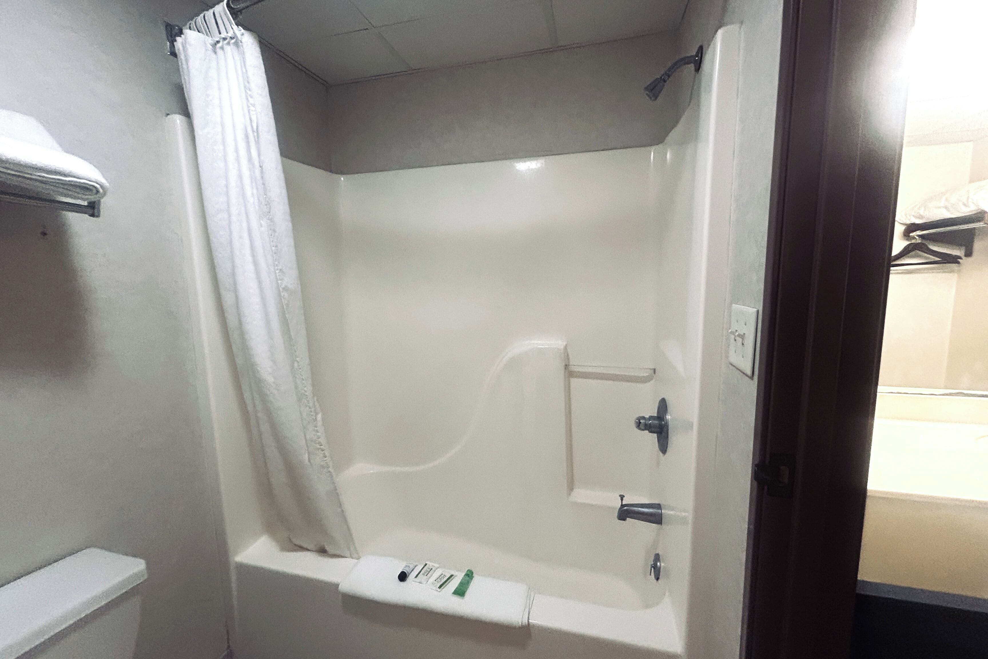Une salle de bain avec une baignoire, un rideau de douche et un porte-serviettes.