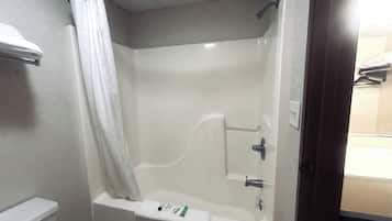 Une salle de bain avec une baignoire, un rideau de douche et un porte-serviettes.
