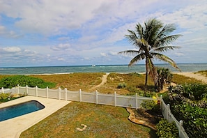 A pool, a white fence, a palm tree, and a beach path leading to the ocean. - Luxury Oceanfront Estate (Pompano Beach)