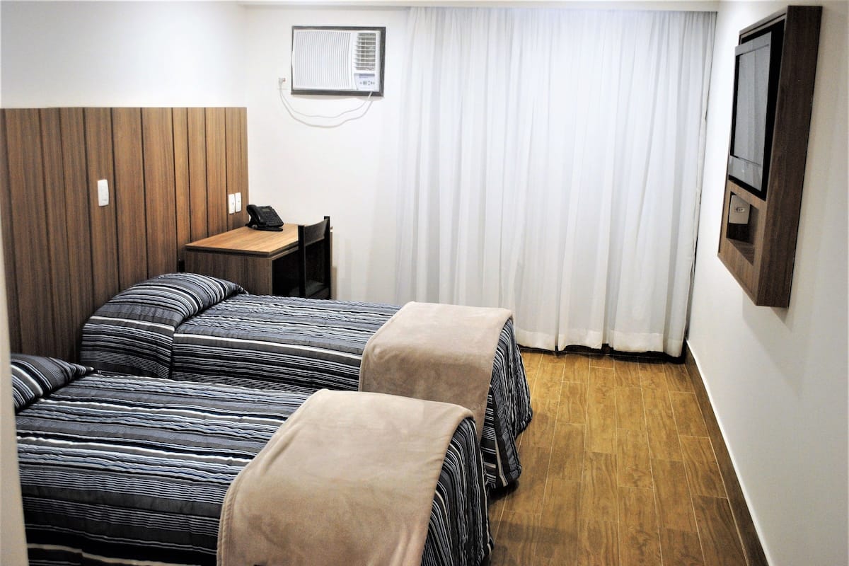 Minibar, escritorio, cortinas blackout y tabla de planchar con plancha