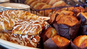 Diversa variedad de productos de pastelería, como pasteles y muffins, exhibidos en una panadería.