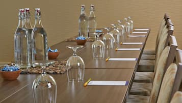 A conference table with glass bottles, wine glasses, and name cards.
