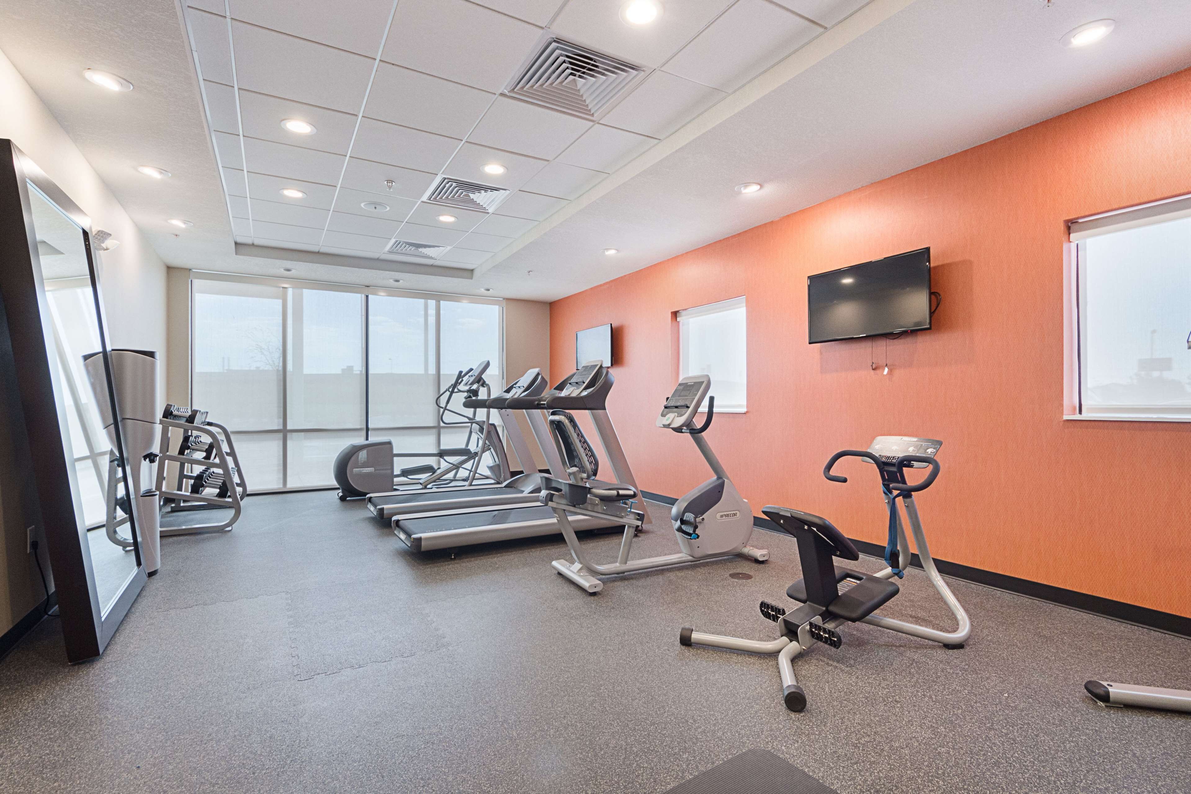A fitness center with treadmills, elliptical machines, and a stationary bike.