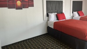 Habitación de hotel con cama, cabecera, una obra de arte colgada en la pared y alfombra estampada.