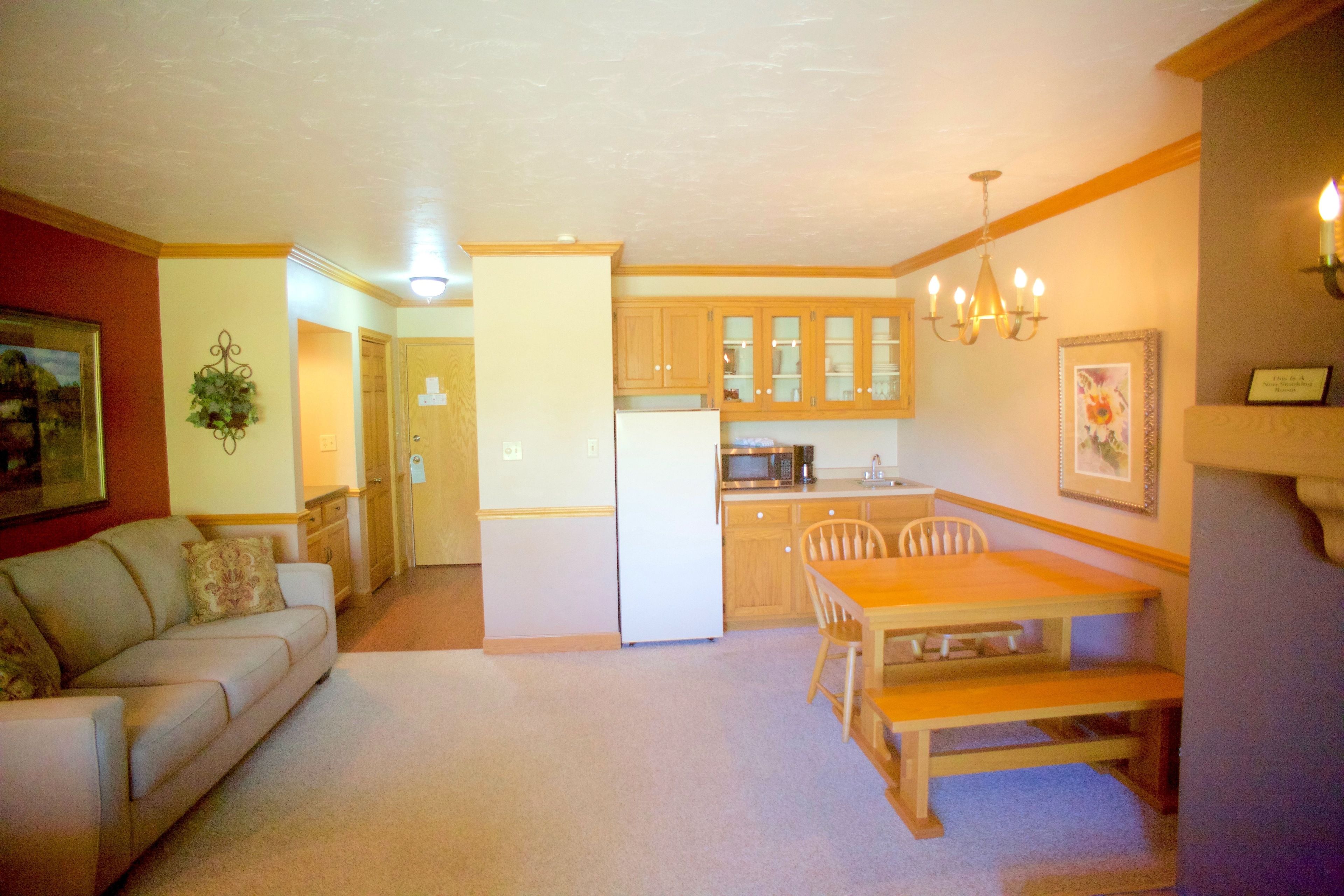 Un espacio habitable compacto con kitchenette, comedor y zona de estar.