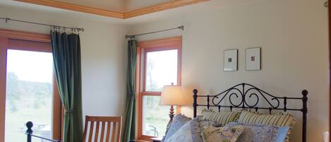 A bedroom with a bed, a chair, a window, and a ceiling fan.
