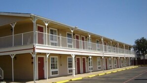 Ein Motel mit einer zweistöckigen Struktur, wobei jede Etage einen Balkon mit weißen Geländern hat.