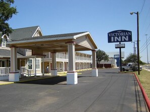 A Victorian Inn with a covered outdoor seating area and a prominent signage. - Victorian Inn (Midland)