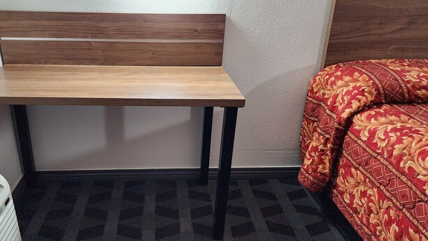 Ein kleiner Raum mit einer Holzbank, einem gemusterten Sofa und einem weißen Heizgerät.
