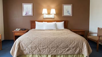 Ein Hotelzimmer mit einem Bett, zwei Nachttischen, einem Sessel und Wandleuchten.