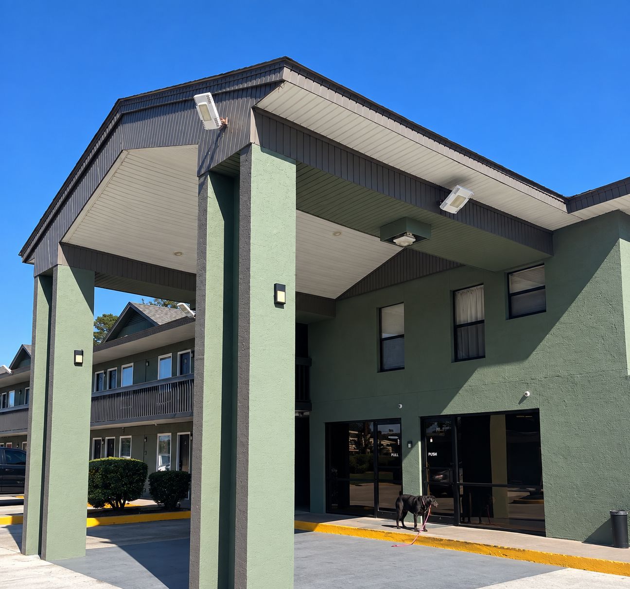 A multi-story building with a flat roof and large windows.