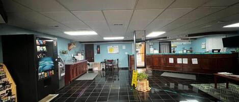 A lobby with a vending machine, a reception desk, and a counter.