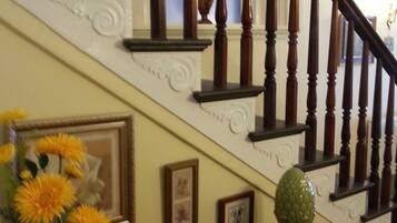 A wooden staircase with a vase of flowers on the landing.