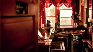 Un espace bar avec un comptoir en bois, des bouteilles et un réfrigérateur.