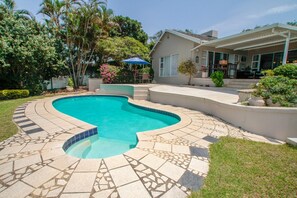 A swimming pool with a curved design, surrounded by a mosaic tile deck. - Chartwell Guest House (Umhlanga)