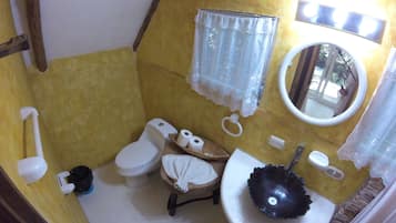 Un baño pequeño con inodoro, lavamanos, espejo y bidé.