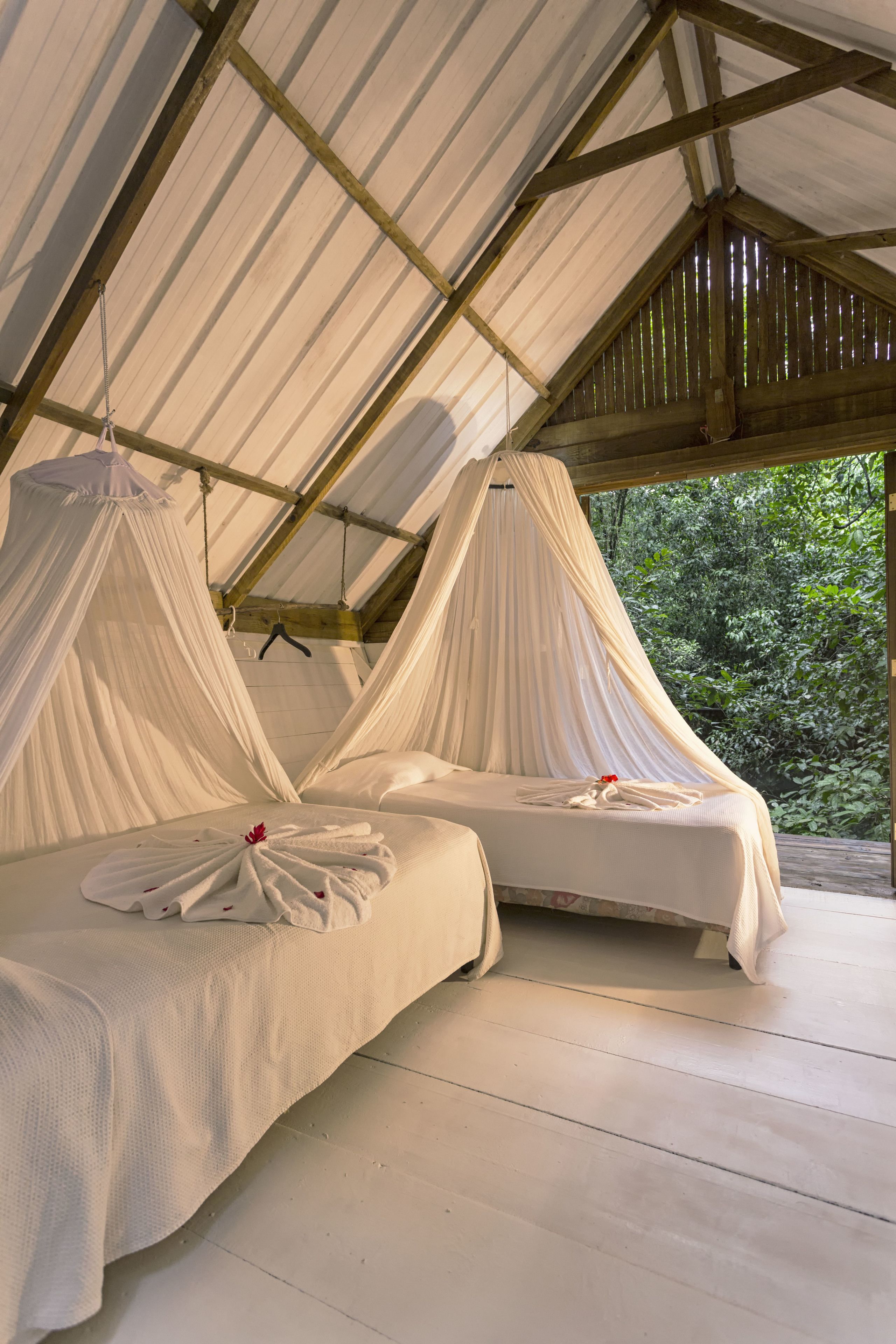 A tented accommodation with two beds, each with a canopy.
