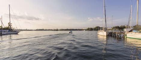Een jachthaven met aangemeerde boten, rustig water en een heldere lucht.