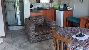 A compact kitchen with a dining area, a built-in microwave, and a television.