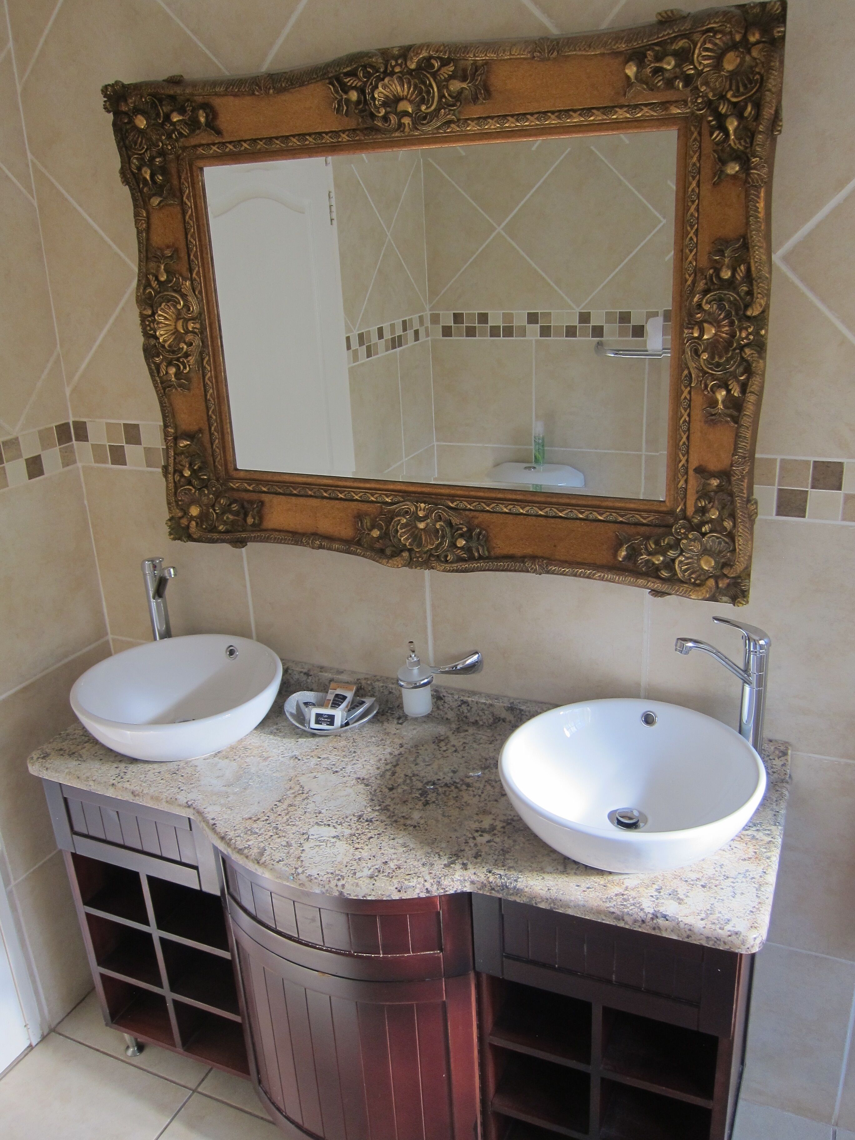 Une salle de bain avec deux lavabos, un miroir et un meuble-lavabo.