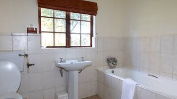 A bathroom with a toilet, sink, and bathtub.