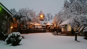 Um pátio coberto de neve com um edifício ao fundo.