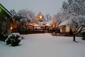 Um pátio coberto de neve com um edifício ao fundo.