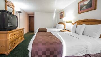 A hotel room with two beds, a wooden dresser, a television, and a framed picture on the wall.