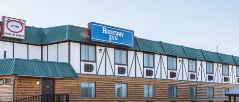 Un bâtiment de style chalet en rondins, avec une enseigne indiquant « Rodeway Inn ».