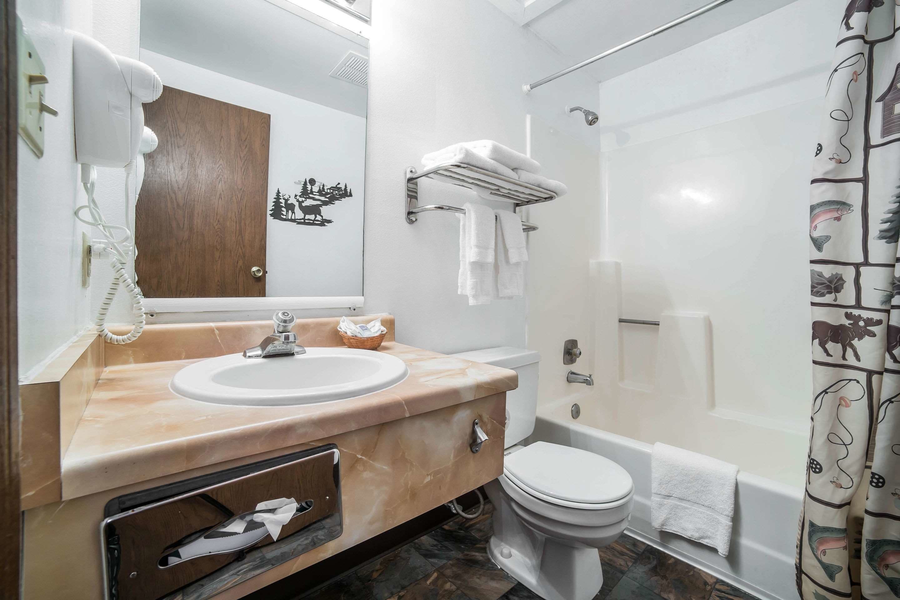 Un baño con lavabo, espejo, toallero y retrete.