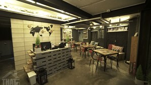 Un intérieur moderne comprenant un comptoir d’accueil, un espace détente et une carte du monde affichée au mur.