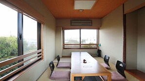 A room with a long table, four chairs, a small heater, and large windows. - Hamayu Kuroshio Sanso (Shirahama)