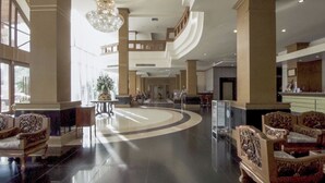 A spacious lobby with high ceilings, a grand chandelier, and a central seating area with ornate chairs. - Arawan Riverside Hotel (Pakse)