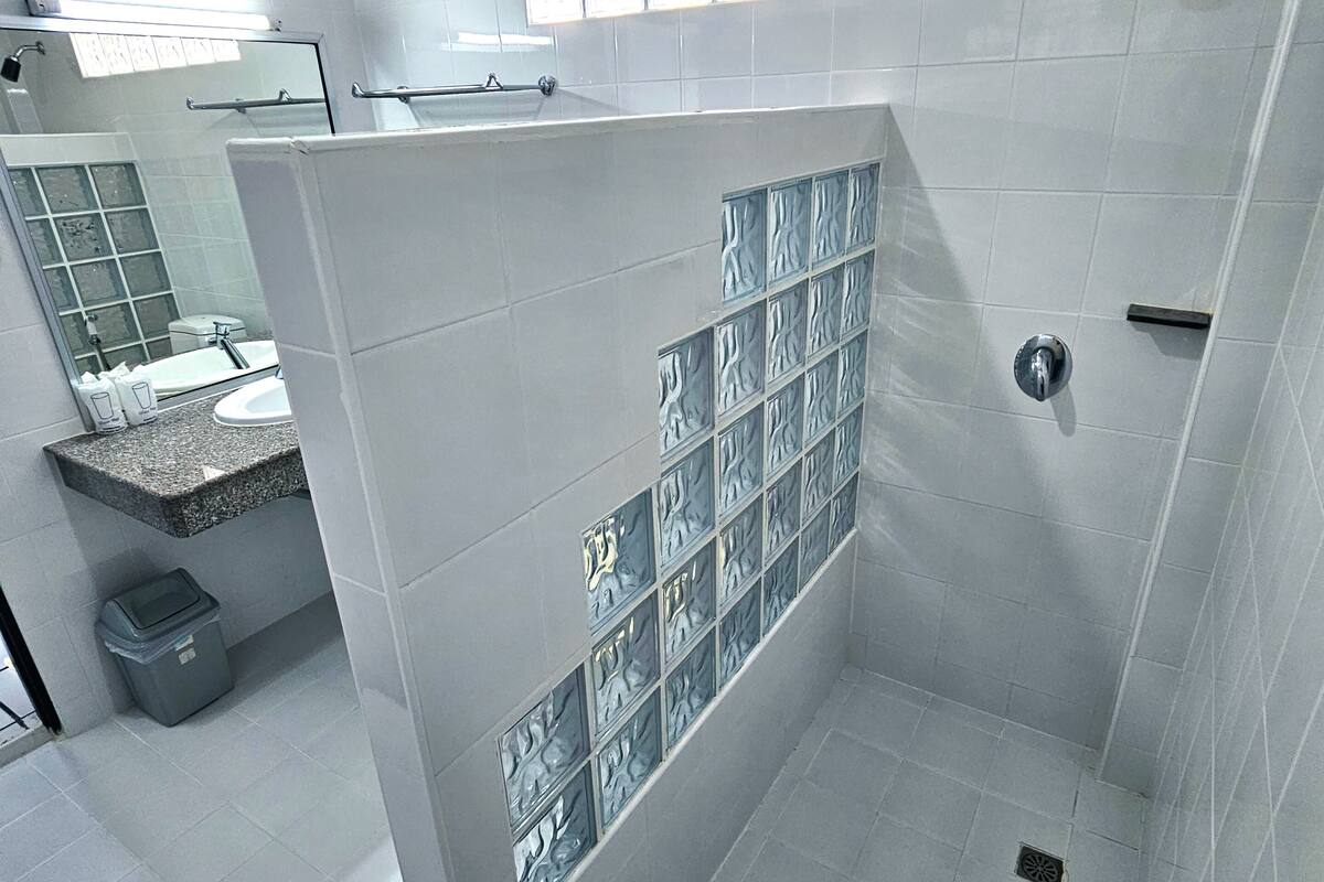 A modern bathroom with a shower, a sink, and a toilet.