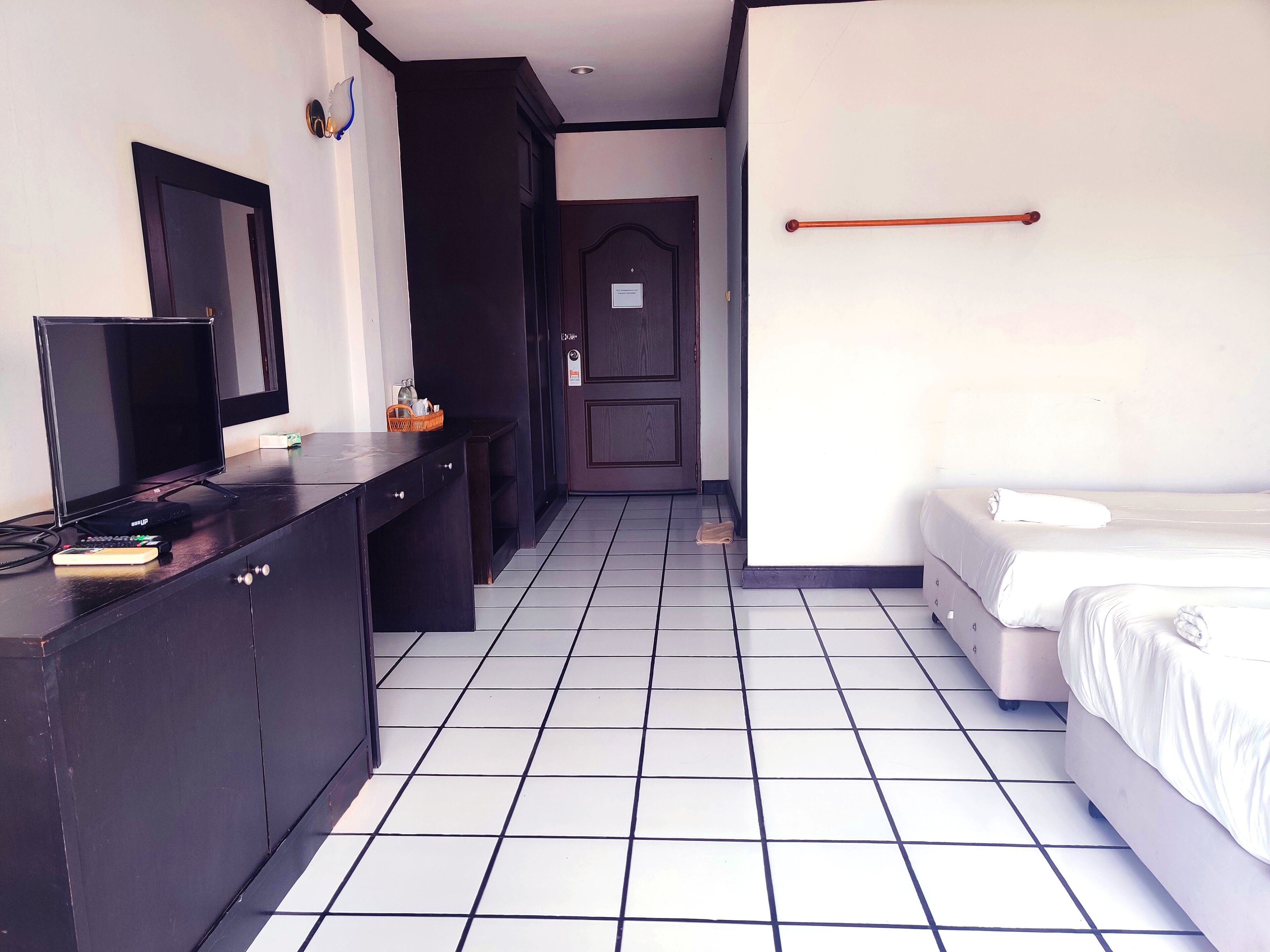 Una habitación de hotel con cama, televisión, escritorio y armario.