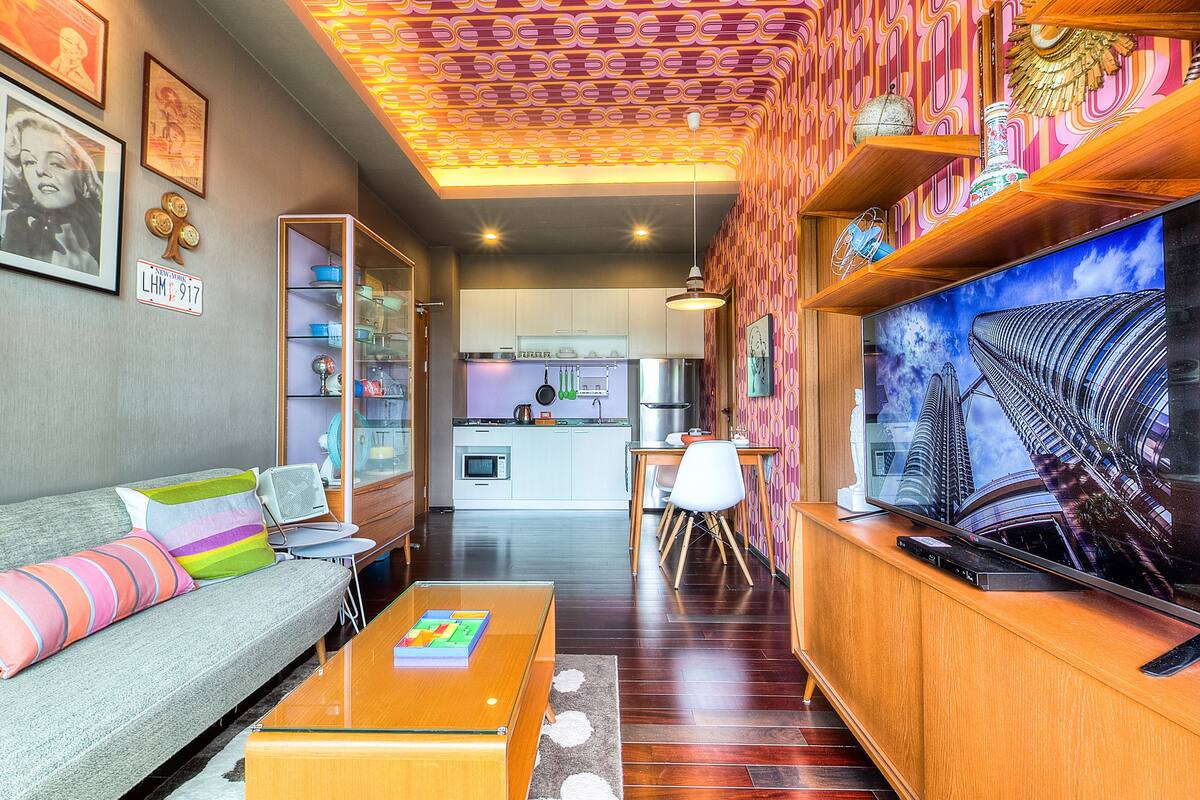 A modern living room with a sofa, coffee table, and a TV on a wooden stand.