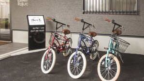 Tres bicicletas estacionadas frente a un edificio con un letrero que indica el horario de atención.
