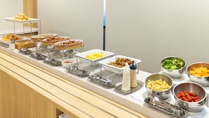A buffet with various food items and serving utensils. - Hotel Wingport (Nagasaki)