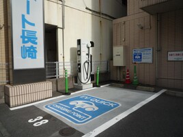 Una estación de carga para vehículos eléctricos, con un letrero que indica que es una estación de carga rápida.