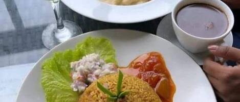 A meal consisting of rice, meat, and vegetables, served on a white plate.