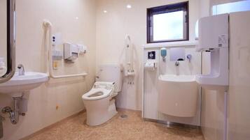 Ein modernes Badezimmer mit Toilette, Waschbecken und Handtrockner.