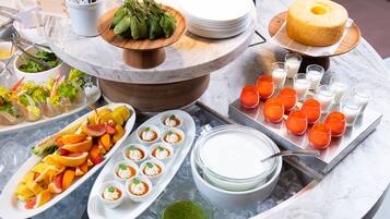 Un bufé con diversos alimentos, incluyendo frutas, ensaladas y postres.